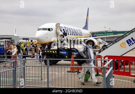 Un Boeing 737-800 sur le tarmac à l'aéroport de Stansted en provenance de Venise. Les passagers débarquent à l'arrivée. L'Italie figure sur la liste des pays de l'Ambre. Banque D'Images