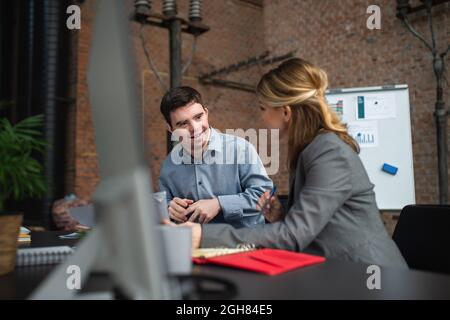 Homme de syndrome de Happy Down avec une femme d'affaires collègue travaillant au bureau, inclusion sociale et concept de coopération. Banque D'Images