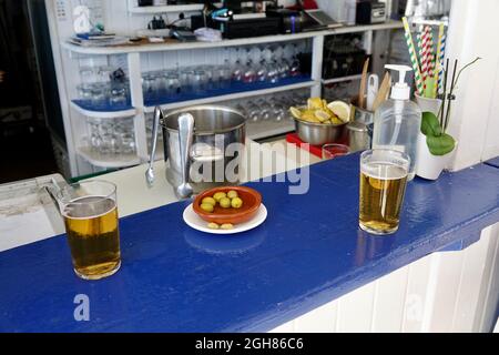 Deux verres de bière et d'olives sur le comptoir du bar de la plage Banque D'Images