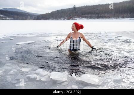 Vue de face d'une femme âgée active en maillot de bain extérieur en hiver, concept de thérapie froide. Banque D'Images