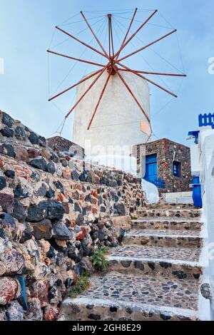 Ancien moulin à vent grec sur l'île de Santorini dans la ville d'Oia avec des escaliers dans la rue. Santorin, Grèce Banque D'Images