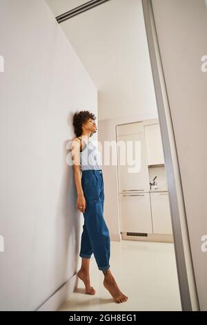 La femme pieds nus rêvant de se pencha contre le mur Banque D'Images