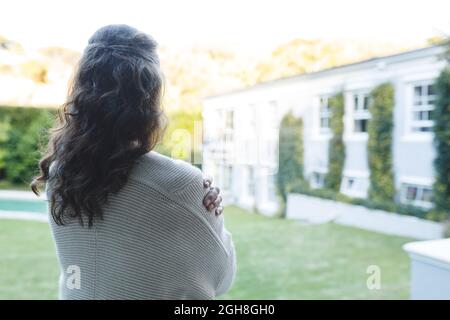 Femme caucasienne âgée debout avec les bras croisés dans le jardin Banque D'Images