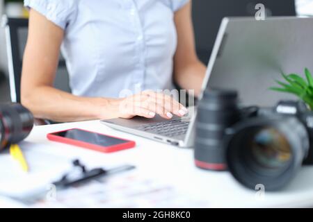 Femme travaille sur l'ordinateur à côté de l'appareil photo Banque D'Images