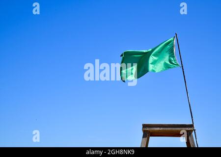 drapeau de chaise de maître-nageur sur la plage sous ciel bleu d'été Banque D'Images