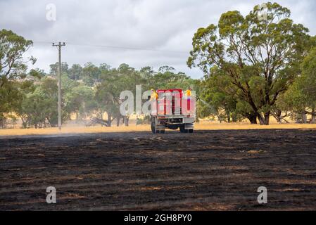 Un appareil d'incendie mettant un feu d'herbe, Langley Barfold, Victoria, Australie. Banque D'Images