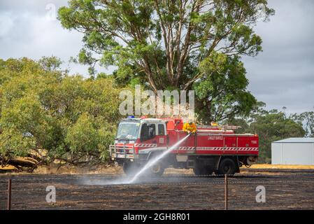 Un appareil d'incendie mettant un feu d'herbe, Langley Barfold, Victoria, Australie. Banque D'Images