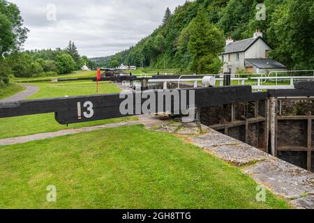 Écluse numéro 13 sur le canal de Crinan avec une maison de gardiens d'écluse abandonnée en arrière-plan. Banque D'Images