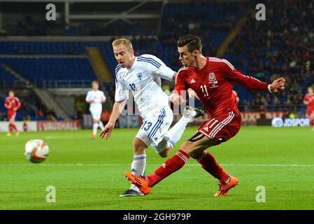 Gareth Bale du pays de Galles bat Kari Arkivuo, de Finlande, et envoie un cliché croisé lors d'un mantch amical international entre le pays de Galles et la Finlande le 16 novembre 2013, au Royaume-Uni, au Cardiff City Stadium. Simon Bellis, Banque D'Images