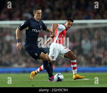 Le 23 septembre 2014, Alexis Sanchez d'Arsenal et Morgan Schneiderlin de Southampton se sont disputer le troisième tour de la coupe Capital One au stade Emirates de Londres. Banque D'Images