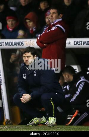 Nigel Clough, directeur de Sheffield Utd, se dresse derrière Mauricio Pochettino, directeur de Tottenham, qui s'est accrouillé sur le terrain lors du match de deuxième pied de la demi-finale de la coupe Capital One Cup entre Sheffield United et Tottenham au stade Bramall Lane à Sheffield, en Angleterre, le 28 janvier 2015. Banque D'Images