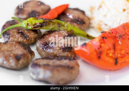 Gros plan sur de délicieux boulettes de viande turques avec du riz, de la tomate et des poivrons. Banque D'Images