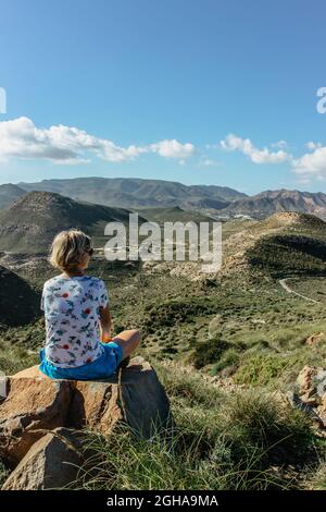 Femme voyageur solo appréciant la vue de Cabo de Gata réserve naturelle, Andalousie, Espagne.zone côtière protégée avec paysage sauvage isolé et volcan Banque D'Images