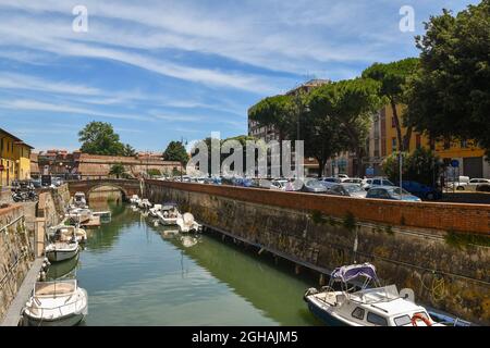 Un canal avec des bateaux dans le quartier de la Nouvelle Venise avec la Nouvelle forteresse (17ème c.) en arrière-plan dans une journée ensoleillée d'été, Livourne, Toscane Banque D'Images