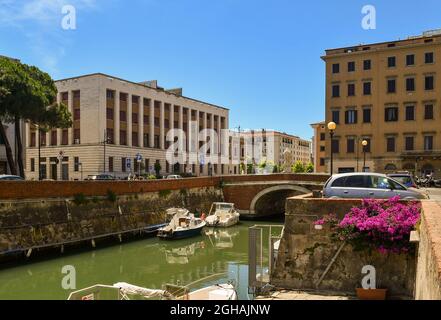 Le pont de St John Nepomuceno au-dessus d'un canal dans la Nouvelle Venise, un quartier semblable à Venise, avec un bougainvillea en pleine floraison en été, Livourne, Toscane Banque D'Images