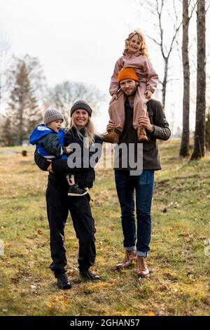 Portrait complet de la famille debout ensemble au parc Banque D'Images