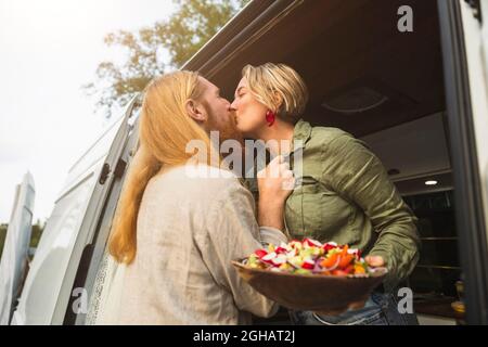 Un jeune couple s'embrasse en se tenant dans un camping-car pendant les vacances Banque D'Images