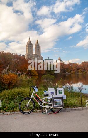 Central Park en automne avec vue sur Upper West Manhattan Skycabper El Dorado. Tombez dans Central Park et un vendeur de rue de photo au bord du lac. Banque D'Images