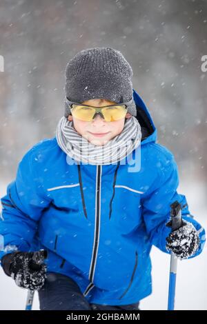 Gros plan sur le ski d'un petit garçon dans le parc d'hiver. Banque D'Images