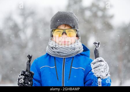 Gros plan sur le ski d'un petit garçon dans le parc d'hiver. Banque D'Images