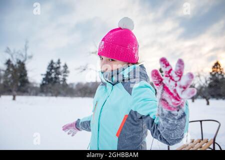 Teengae fille s'amusant à jouer avec le traîneau dans la neige en hiver. Banque D'Images