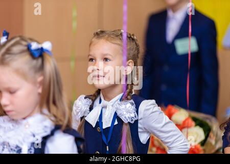 Les élèves de première classe effectuent un échauffement en se tenant debout. Elle est à l'école de première année. Moscou, Russie, 1er septembre 2021 Banque D'Images