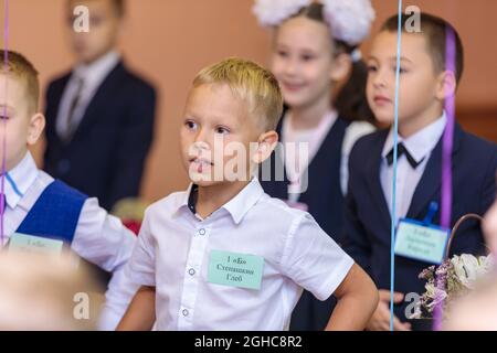 Les élèves de première classe effectuent un échauffement en se tenant debout. Elle est à l'école de première année. Moscou, Russie, 1er septembre 2021 Banque D'Images