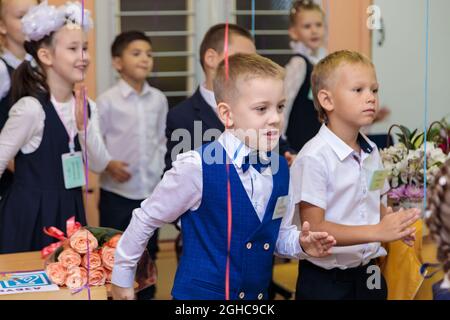 Les élèves de première classe effectuent un échauffement en se tenant debout. Elle est à l'école de première année. Moscou, Russie, 1er septembre 2021 Banque D'Images