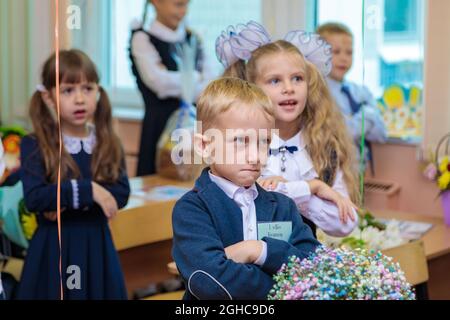 Les élèves de première classe effectuent un échauffement en se tenant debout. Elle est à l'école de première année. Moscou, Russie, 1er septembre 2021 Banque D'Images