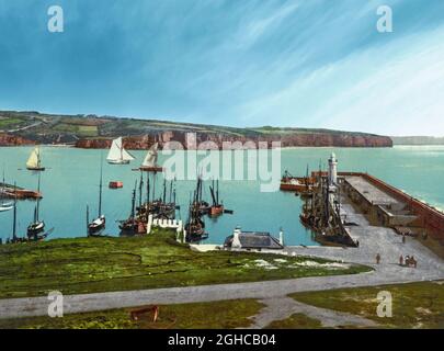 Une vue du début du XXe siècle sur le port de Dunmore East, un village touristique et de pêche populaire dans le comté de Waterford, en Irlande. Situé à l'ouest du port de Waterford, sur la côte sud-est de l'Irlande, il se trouve à l'intérieur de la baronnie de Gaultier (Gáll Tír – « terre d'étrangers » en irlandais), une référence à l'afflux de colons viking et normands dans la région. Banque D'Images