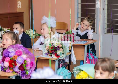 Le 1er septembre, les enfants s'assoient à leur bureau en classe. Les élèves de première année écoutent attentivement l'enseignant dans la première leçon. Moscou, Russie, septembre 202 Banque D'Images