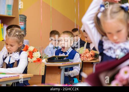 Le 1er septembre, les enfants s'assoient à leur bureau en classe. Les élèves de première année écoutent attentivement l'enseignant dans la première leçon. Moscou, Russie, septembre 202 Banque D'Images