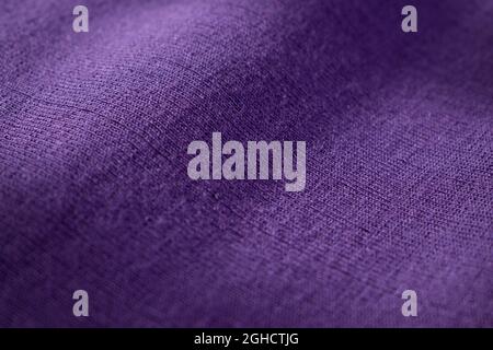 Gros plan sur la texture en laine tricotée violette d'un pull avec ombres Banque D'Images