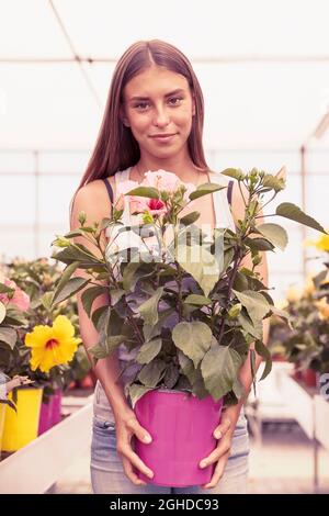 jeune vendeur de fleurs prend soin de ses belles fleurs sur un vintage chaud couleur filtrée look Banque D'Images