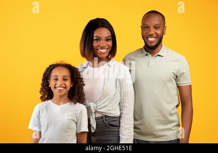 Personnes, concept de portait de famille. Heureux africain américain homme, femme et fille posant pour la photo et souriant à la caméra Banque D'Images