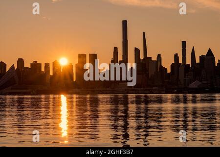 New York, NY - Etats-Unis - 4 septembre 2021 : image horizontale de la ligne d'horizon de l'ouest de Manhattan au lever du soleil, avec des réflexions vues dans le fleuve Hudson Banque D'Images