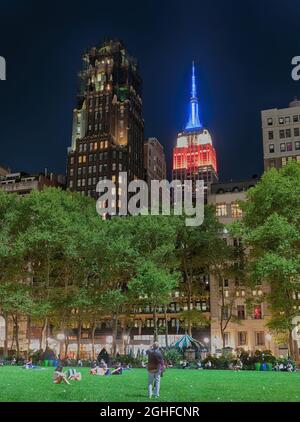 Deux monuments - Empire State Building et American Radiator Building (aujourd'hui l'hôtel Bryant Park), vus pendant une nuit d'été depuis Bryant Park. Banque D'Images