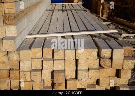 Piles de planches de bois à la scierie pour la fabrication de revêtements. Entrepôt de planches en plein air pour la construction de maisons. Bois en s Banque D'Images