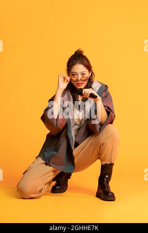 Photo de studio de jeune femme à la mode chantant Banque D'Images