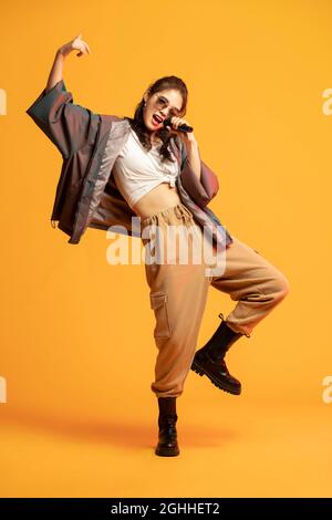 Photo de studio de jeune femme à la mode chantant Banque D'Images