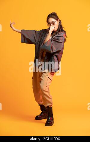 Photo de studio de jeune femme à la mode chantant Banque D'Images