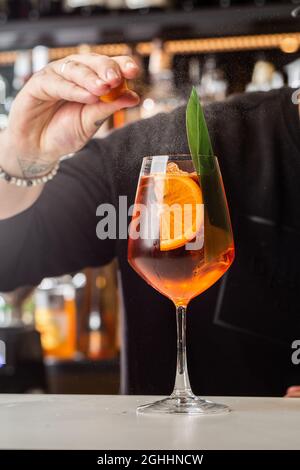 Barman se préparant sur le comptoir Aperol Spritz, un apéritif italien classique et rafraîchissant préparé à la fois par Aperol, Prosecco et mousseux Banque D'Images