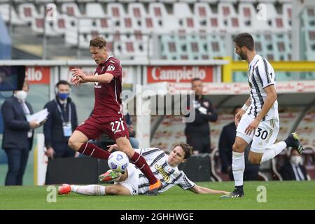 Federico Chiesa de Juventus challenges Mergim Vojvoda de Torino FC comme Rodrigo Bentancur de Juventus regarde pendant la série Un match au Stadio Grande Torino, Turin. Date de la photo : 3 avril 2021. Le crédit photo doit être lu : Jonathan Moscrop/Sportimage via PA Images Banque D'Images