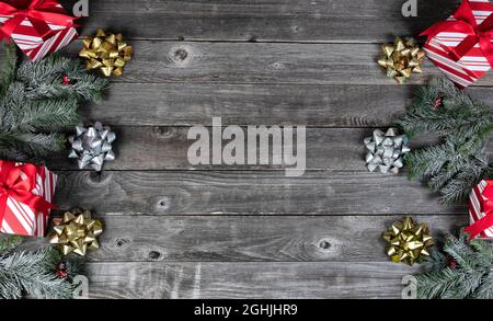 Boîtes-cadeaux, arcs dorés et argentés plus décorations de branches de sapin sur des planches rustiques en bois pour un joyeux Noël ou de bonnes fêtes du nouvel an celebratio Banque D'Images