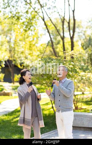 Joyeux couple senior chantant avec des microphones Banque D'Images