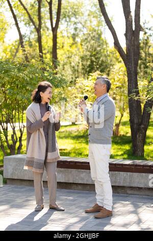 Joyeux couple senior chantant avec des microphones Banque D'Images