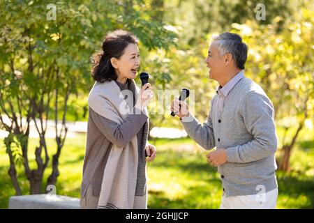 Joyeux couple senior chantant avec des microphones Banque D'Images