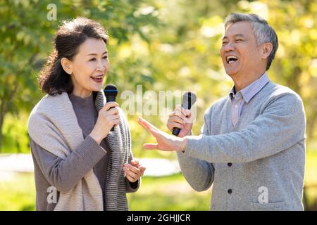 Joyeux couple senior chantant avec des microphones Banque D'Images