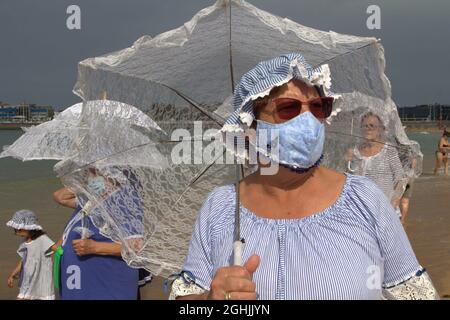 Espagne. 06e septembre 2021. L'association des femmes libres de la corredoria commencent leurs bains à vagues, avec des promenades thérapeutiques, des parasols blancs, des chemisiers en dentelle, des pyjamas à rayures bleues et des bonnets de bain marchant à travers la plage de San Lorenzo à Gijon. (Photo de Mercedes Menendez/Pacific Press) crédit: Pacific Press Media production Corp./Alay Live News Banque D'Images