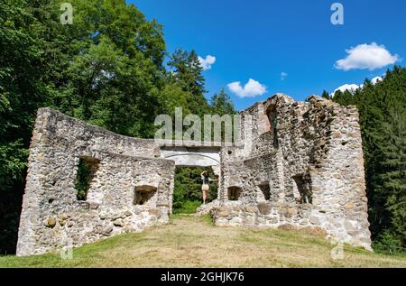 Vue arrière de la jeune femme debout à la porte de l'ancien fort de la ruine lors d'une journée ensoleillée d'été. Banque D'Images